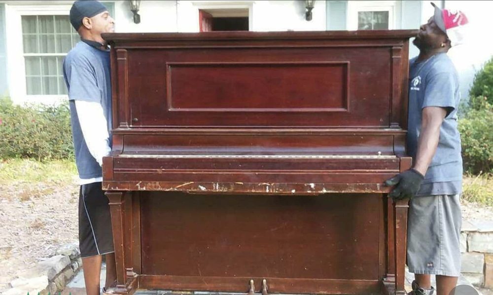 An ICANN mover preparing a baby grand piano for transport